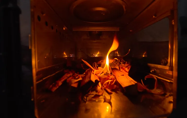 En lågande eld i en kamin med glödande ved.