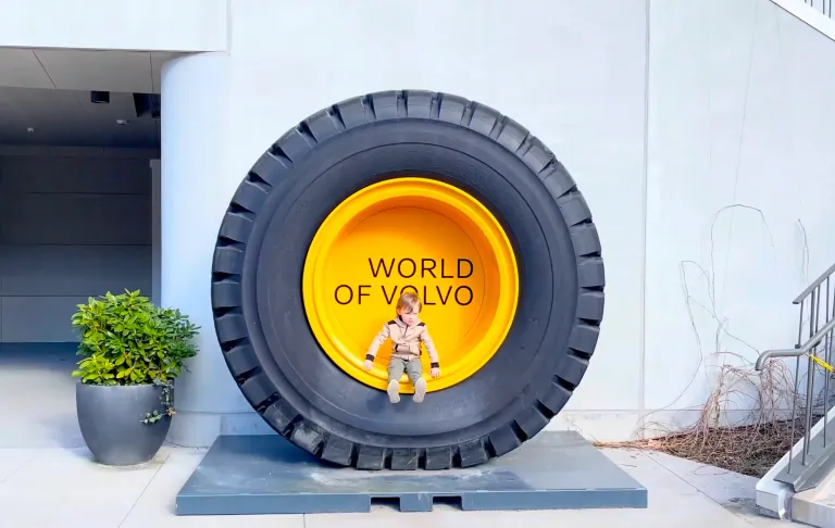 Een grote Volvo band met de tekst 'WORLD OF VOLVO' en een speelgoedfiguur vooraan.