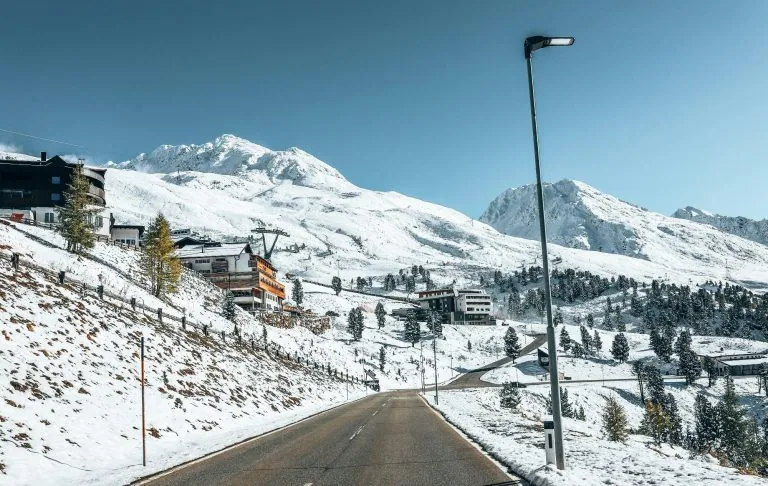 Winterlandschaft mit schneebedeckten Bergen und einer Straße, die durch das Tal führt.
