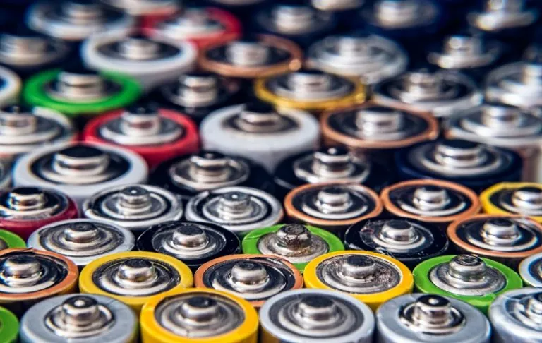 En samling av olika batterier i flera färger, med metalliska toppar.