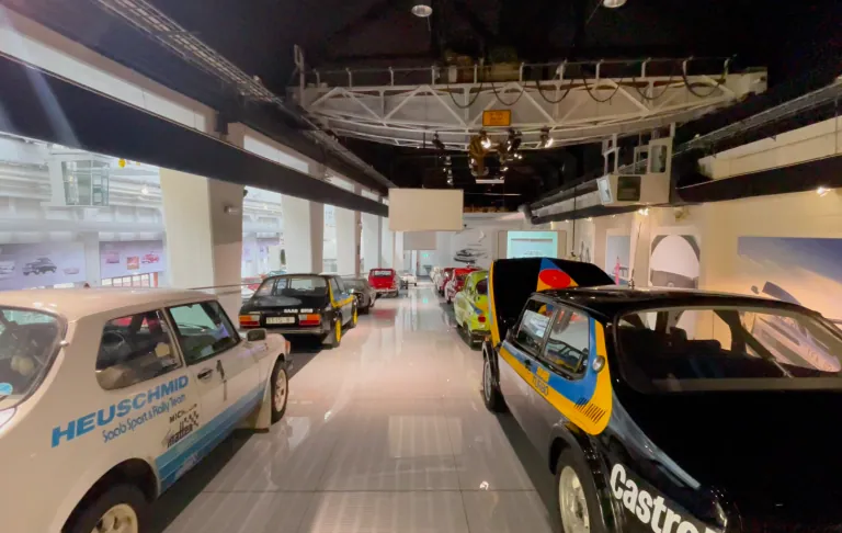 Ausstellung mit mehreren Oldtimern in einem modernen Autosalon.