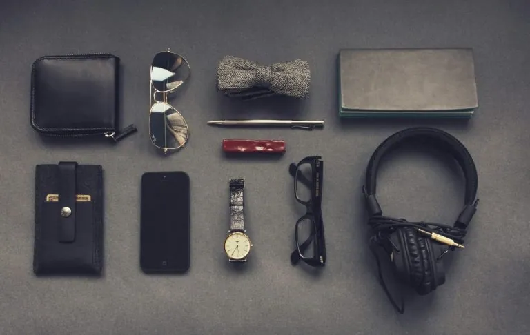 A collection of accessories: wallet, watch, glasses, headphones and more.