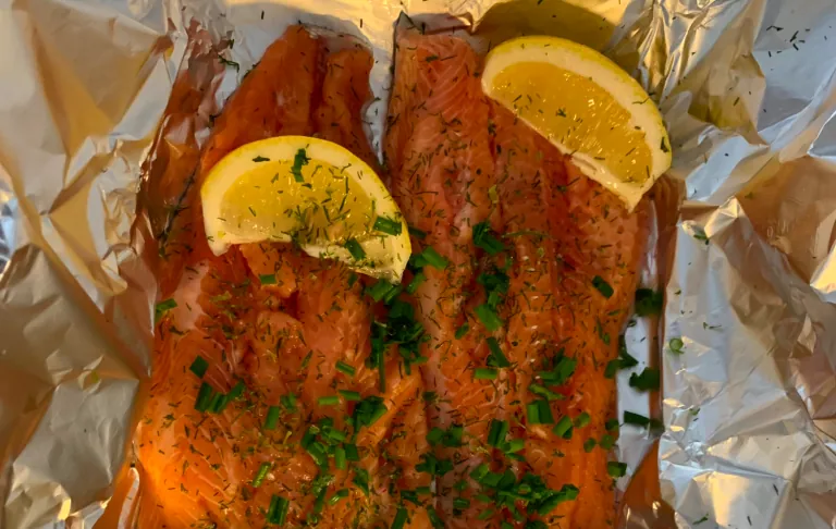 Grillet laks med sitronskiver og en frisk touch på aluminiumsfolie.