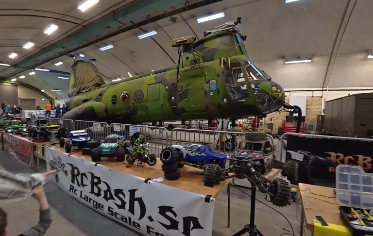 Grön, stor modell av en helikopter placerad på ett bord med radiostyrda fordon.