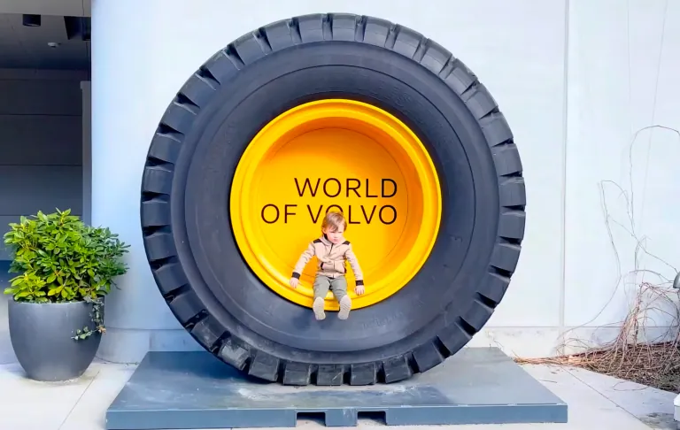 En stor däckskulptur med texten "WORLD OF VOLVO" och en leksakstfigur framför.
