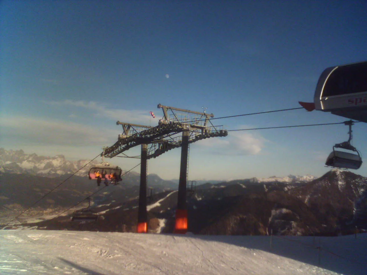 Space Jet stolliften i Flachau med en gondol og pister i aftenlys, bjerge i baggrunden