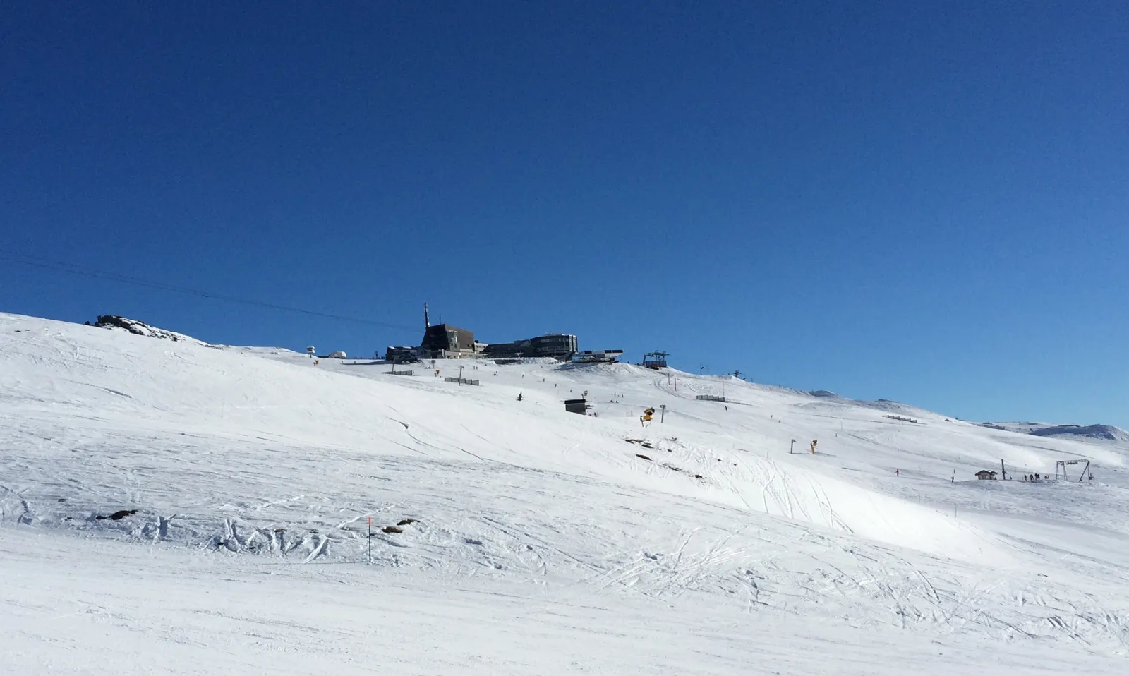Breda, preparerade pister upp mot toppstationen Crap Sogn Gion i Laax under klarblå himmel