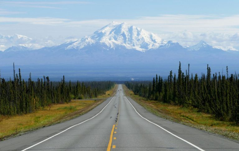 Alaska road Flod som slingrar sig genom ett höstfärgat landskap med berg i bakgrunden.
