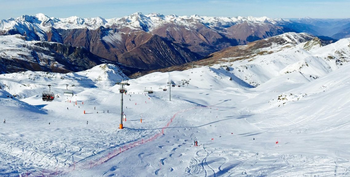 Snöklädda alpberg med klara, blå himmel i bakgrunden. Vinterlandskap.