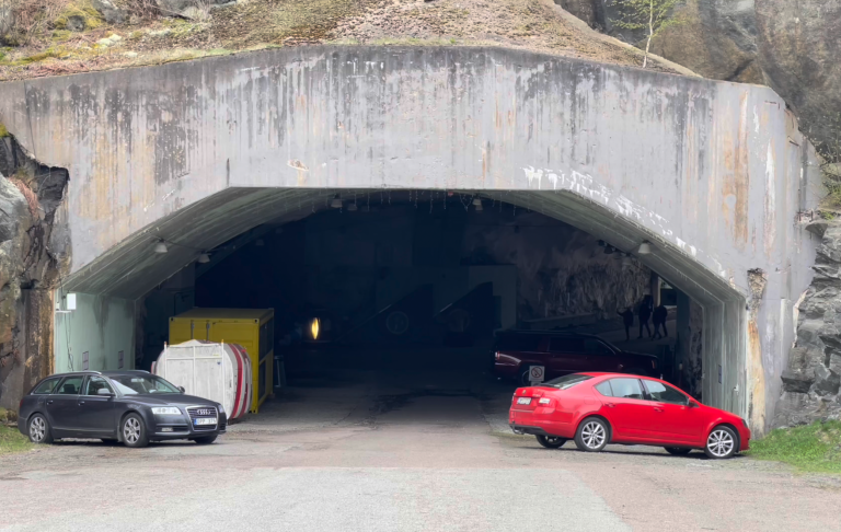 Aeroseums Entre Ingång till en tunnel med två parkerade bilar på sidan.