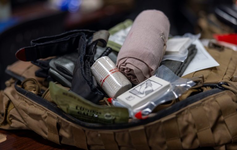 Första Hjälpen väska Ett ställ med förstahjälpenutrustning och överlevnadsartiklar i en ryggsäck.