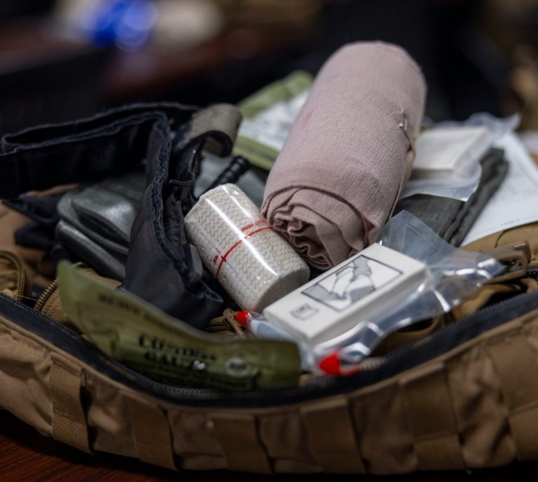 Första hjälpen-kit med förband och medicinska material i en ryggsäck.