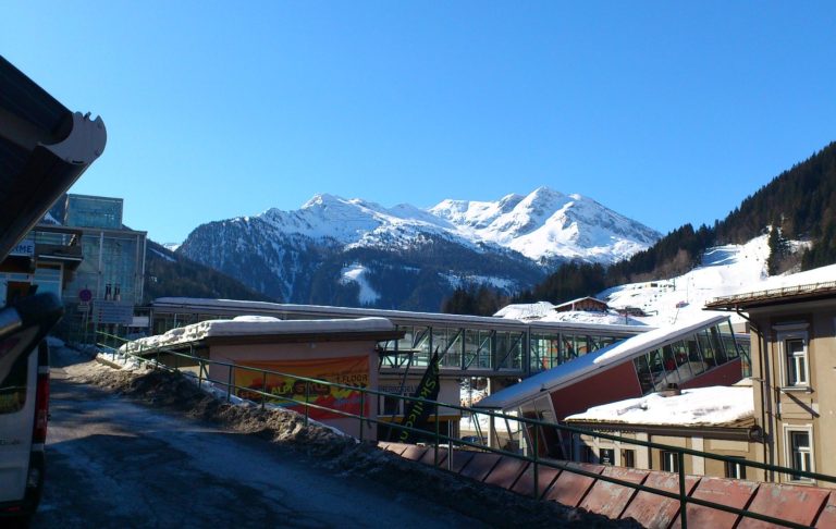 Fjällandskap med snötäckta berg och byggnader i en vintermiljö.