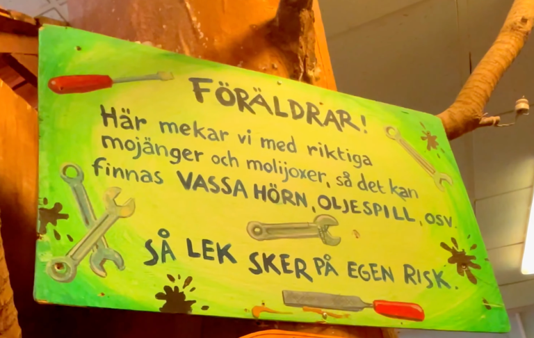 Skylt som informerar föräldrar om risker och försiktighetsåtgärder på lekplats.