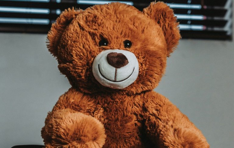 En brun, mjuk nallebjörn med ett stort leende.