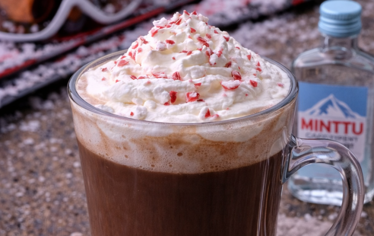 Kopp med varm choklad toppad med grädde och krossad pepparmint.