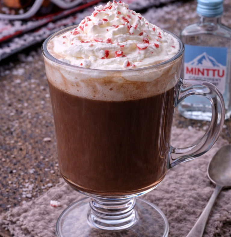 Varm choklad efter en dag i skidbacken – med grädde eller mintu Kopp med varm choklad, grädde och strössel av pepparmint på toppen.