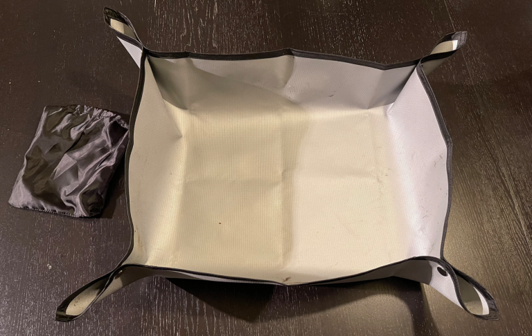 En vikbar, fyrkantig förvaringslåda med svarta och vita kanter.