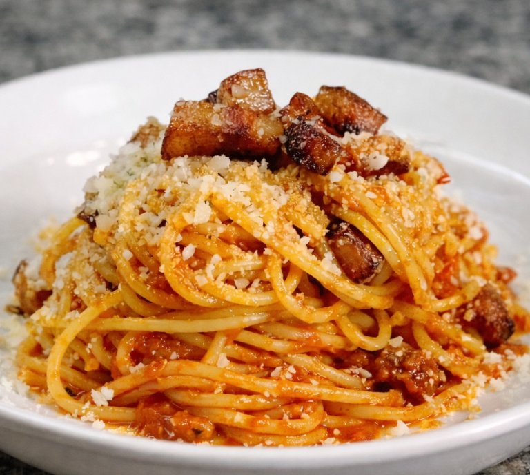 Tallrik med spaghetti i tomatsås, toppad med parmesan och persilja. Pasta all’Amatriciana 