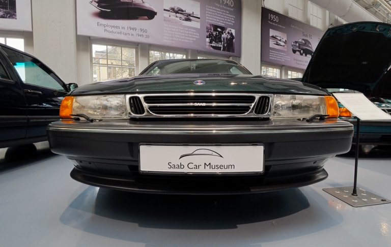 Saab 9000 Gröna bilmodell från 1990-talet med bakåtsträvande design i en utställning.