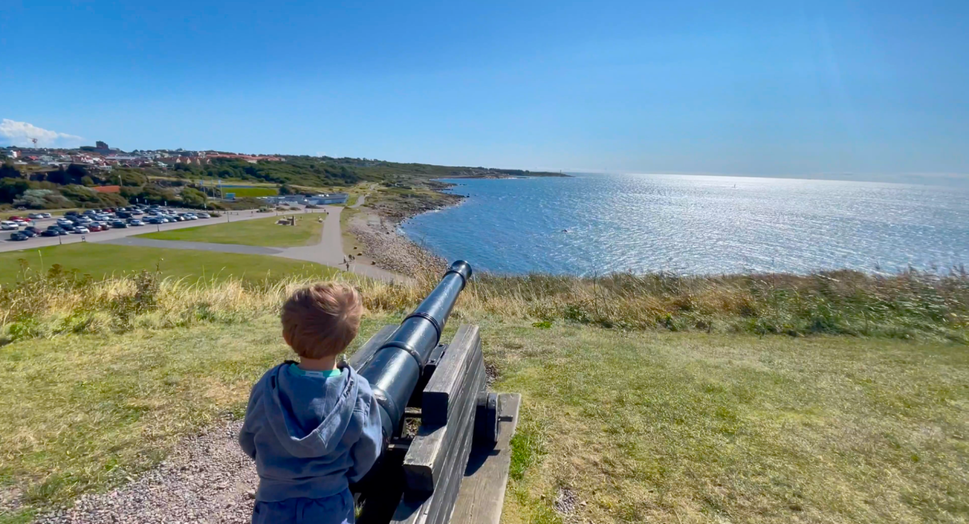 Kanon mot havet Varbergs Fästning Ett barn tittar ut över havet från en utsiktsplats med en kikare.