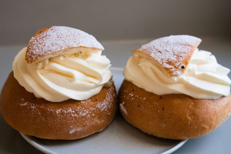 Två semlor med vispgrädde och ett lock av vetebulle.