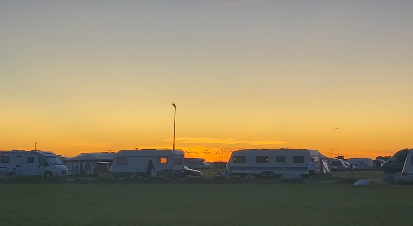 Solnedgång över Campingen i Björkäng Campingscener med husvagnar under en färgglad solnedgång.