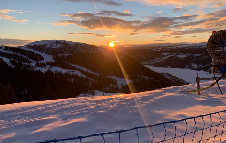 Solnedgång över snötäckta fjäll och en frusen sjö från VM6 i Åre