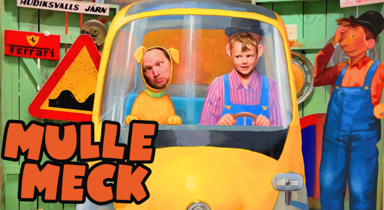 Besöker Mulle Meck i Hudiksvall Barn i en gul lastbil leker, omgivna av färgglada verktyg och skyltar.