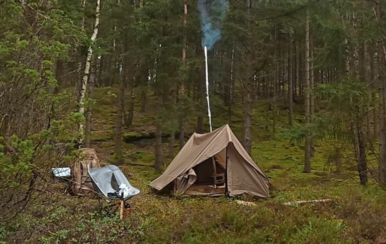 Man med keps står i en bilutställning med flera klassiska bilar i bakgrunden.