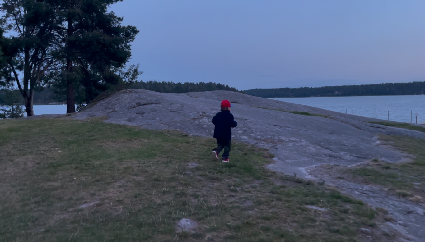 Upptäcksfärd Barn som springer längs en grusig strand vid en sjö vid skymning.
