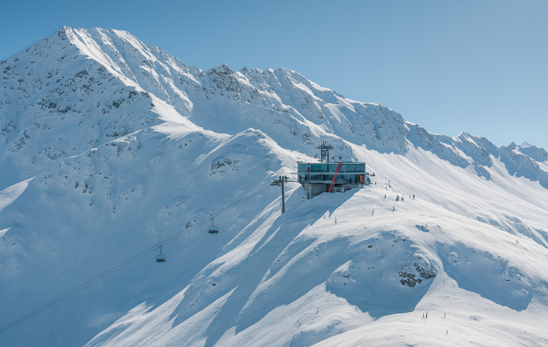 illustration av Snötäckta berg med en skidlift som sträcker sig uppåt i klart väder.