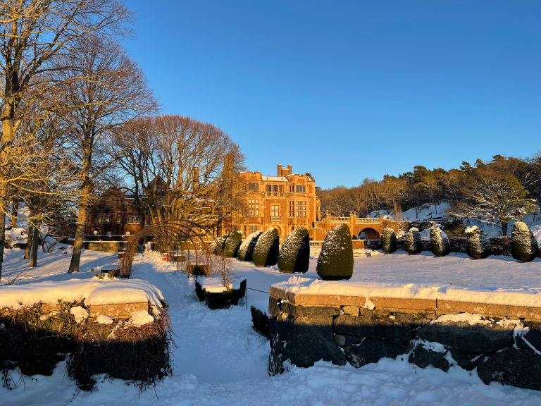 Familj på skidort vid solnedgång, omgiven av snö och skidbackar.