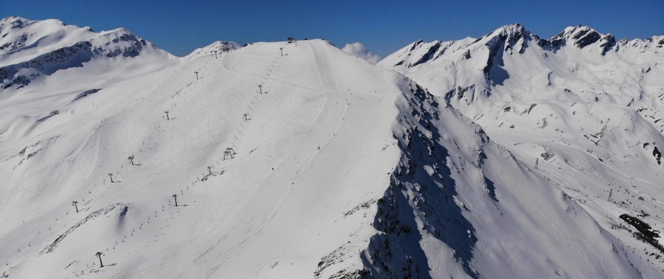 La Thuile - Italien Vitt snölandskap med bergstoppar och klarblå himmel.