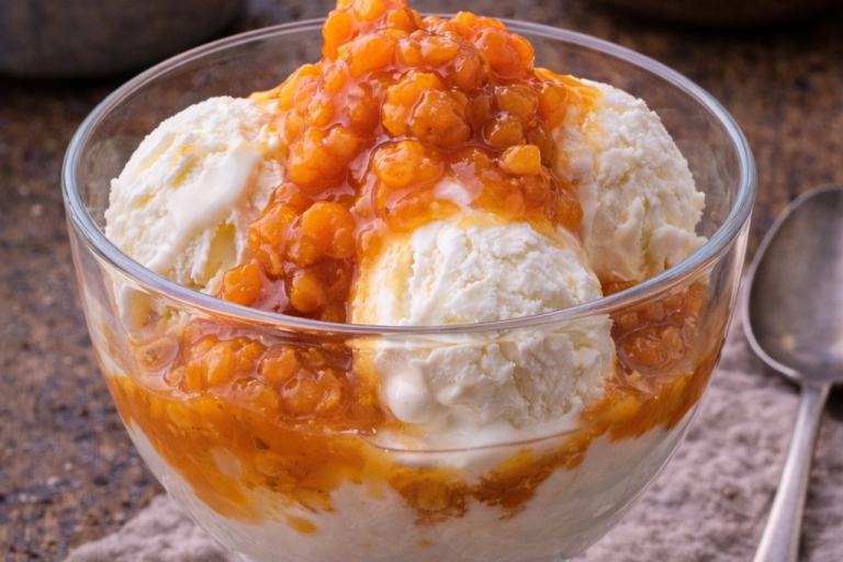 Skål med glass toppad med orangefruktkompott.