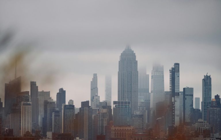 Stadssilhuett med dimma över moderna skyskrapor.