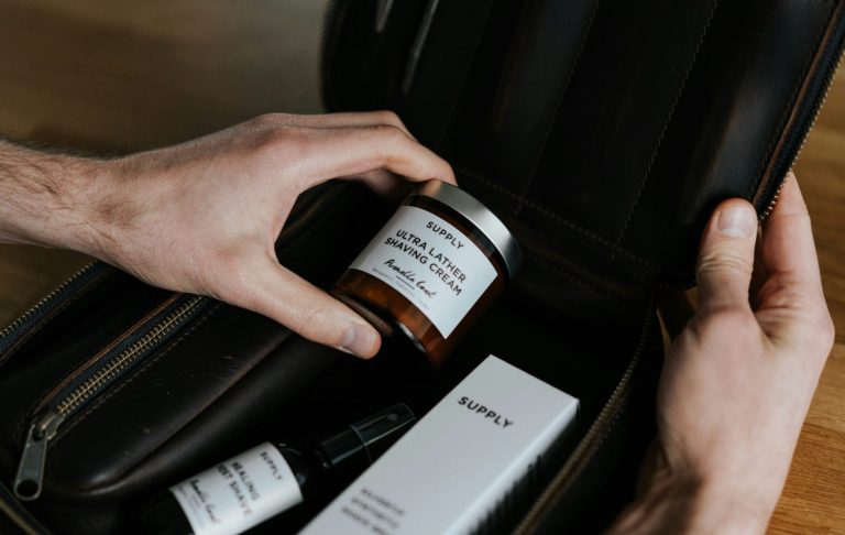 Händer som plockar upp en burk och använt hudvårdsprodukter i en väska.