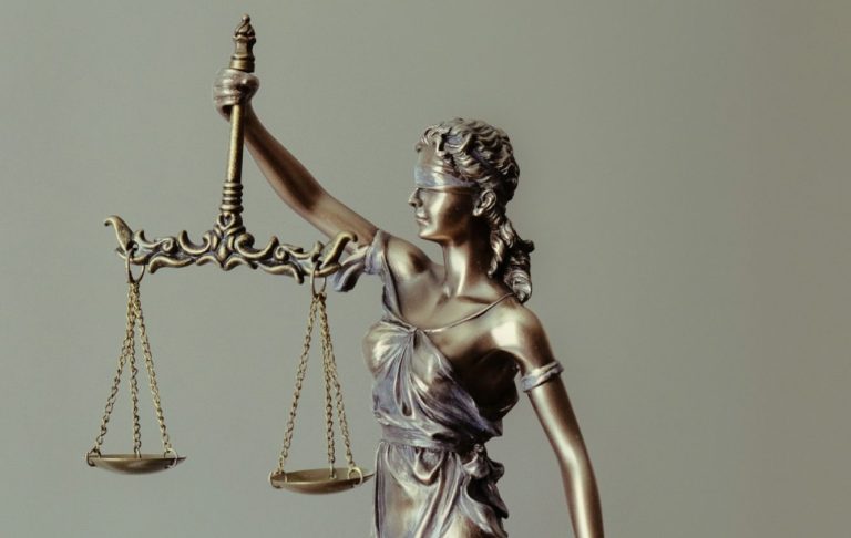 Staty av Justitia, en kvinna med vågskål och svärd, symboliserar rättvisa.