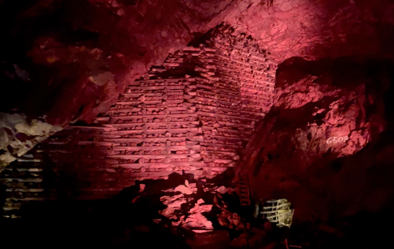 Stenstruktur i en grotta, belyst av rött ljus.
