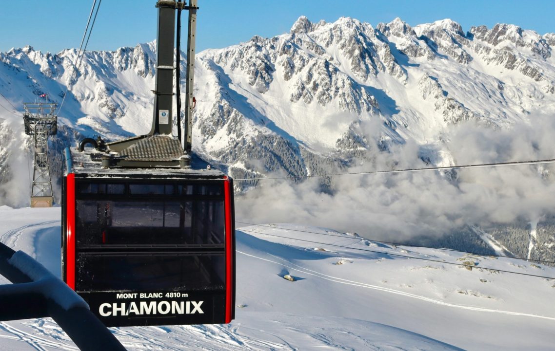 Gondoltransport med snötäckta alpberg i bakgrunden, Chamonix.