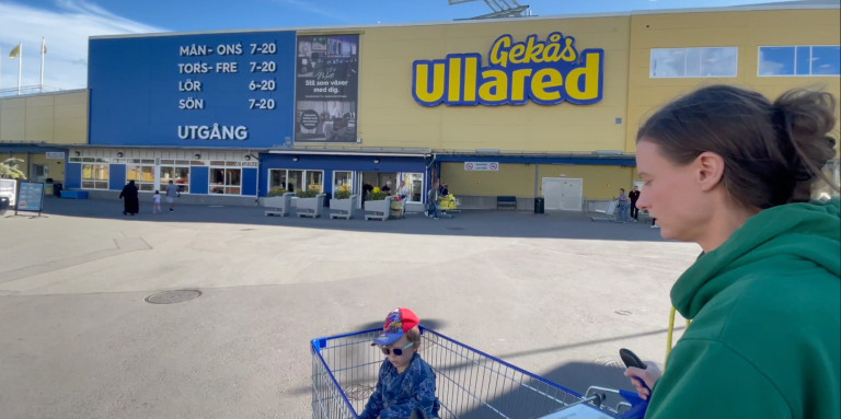 En person står vid ingången till butiken Ullared med en kundvagn.