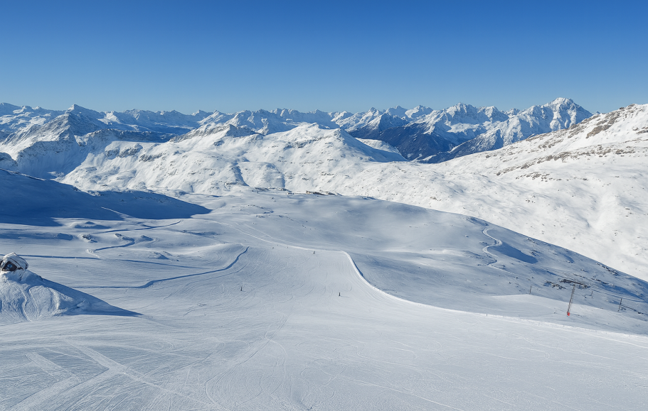 Illustration av Utsikt över snöklädda berg och en by i dalen under en klar himmel.