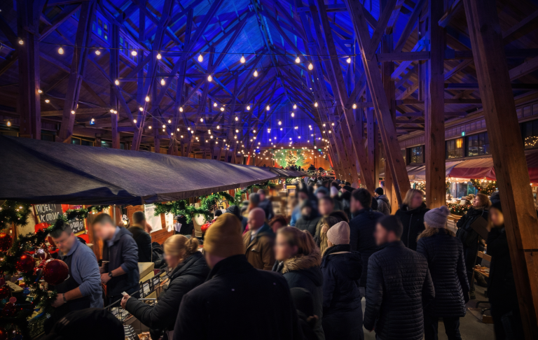 Folkmassa under en upplyst takstruktur med blått ljus.