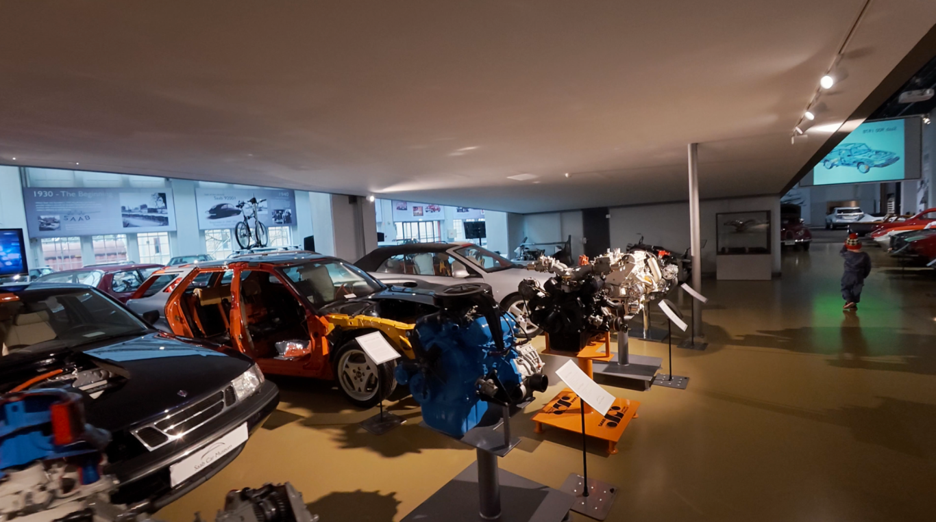 Motorer Bilutställning med flera klassiska bilar och motorer i en modern museimiljö.