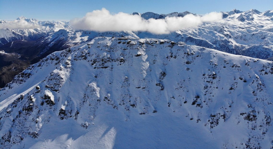 La Thuile - Italien Fjäll med snöklädda toppar och moln, vidsträckta vyer i en klar himmel.