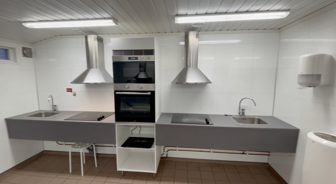 Servicehuset Kök Björkäng Modernt kök med två diskhoar, spisar och ugnar i en ljus, ren miljö.