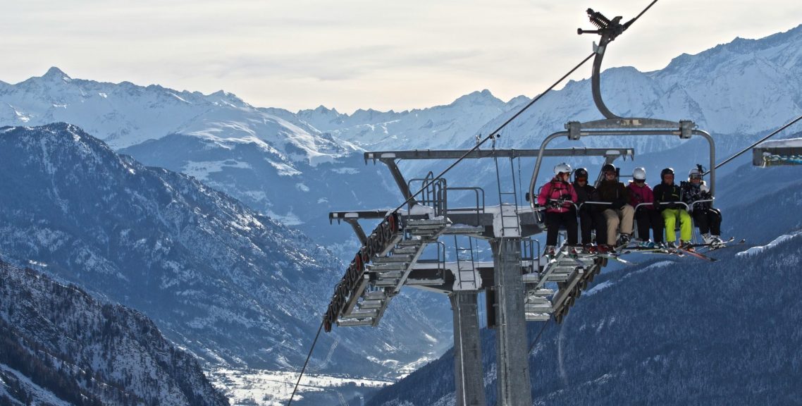 Courmayeur - Italien Stolslift som transporterar åkare över snötäckta berg.