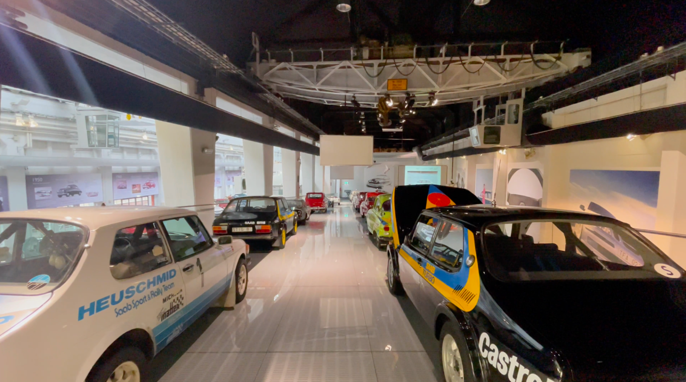 Rallybilarna i Bilsalongen på Saab Car Museum Utställning med flera klassiska bilar i en modern bilsalong.