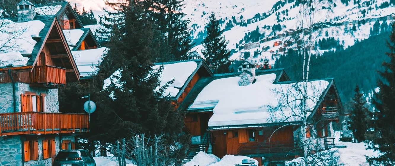 Skidorter med liftar och snötäckta alpberg i bakgrunden.