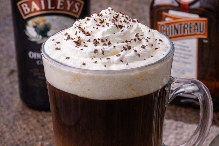 En kopp med irländsk kaffe toppad med grädde och chokladflarn.